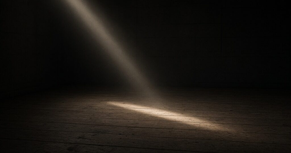 A thin beam of daylight across a dark wooden floor.