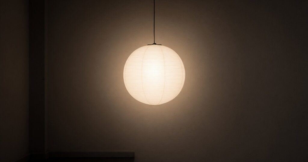 A paper lantern glowing in a dark room.