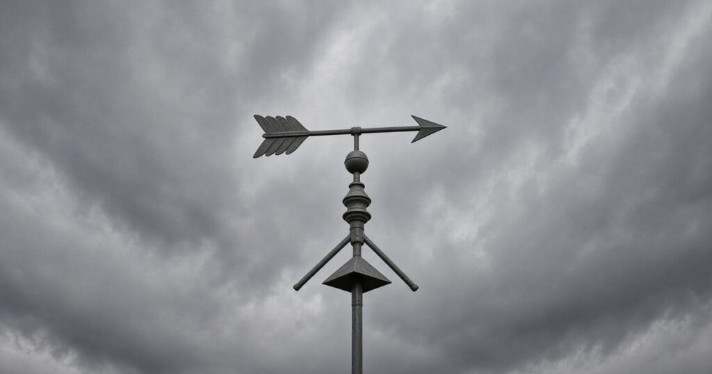 A steel weather vane against a brooding gray sky.